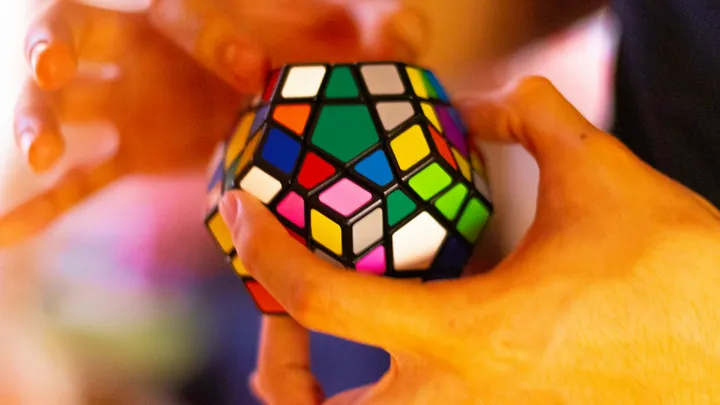 person holding 3 x 3 rubiks cube by Alan De La Cruz