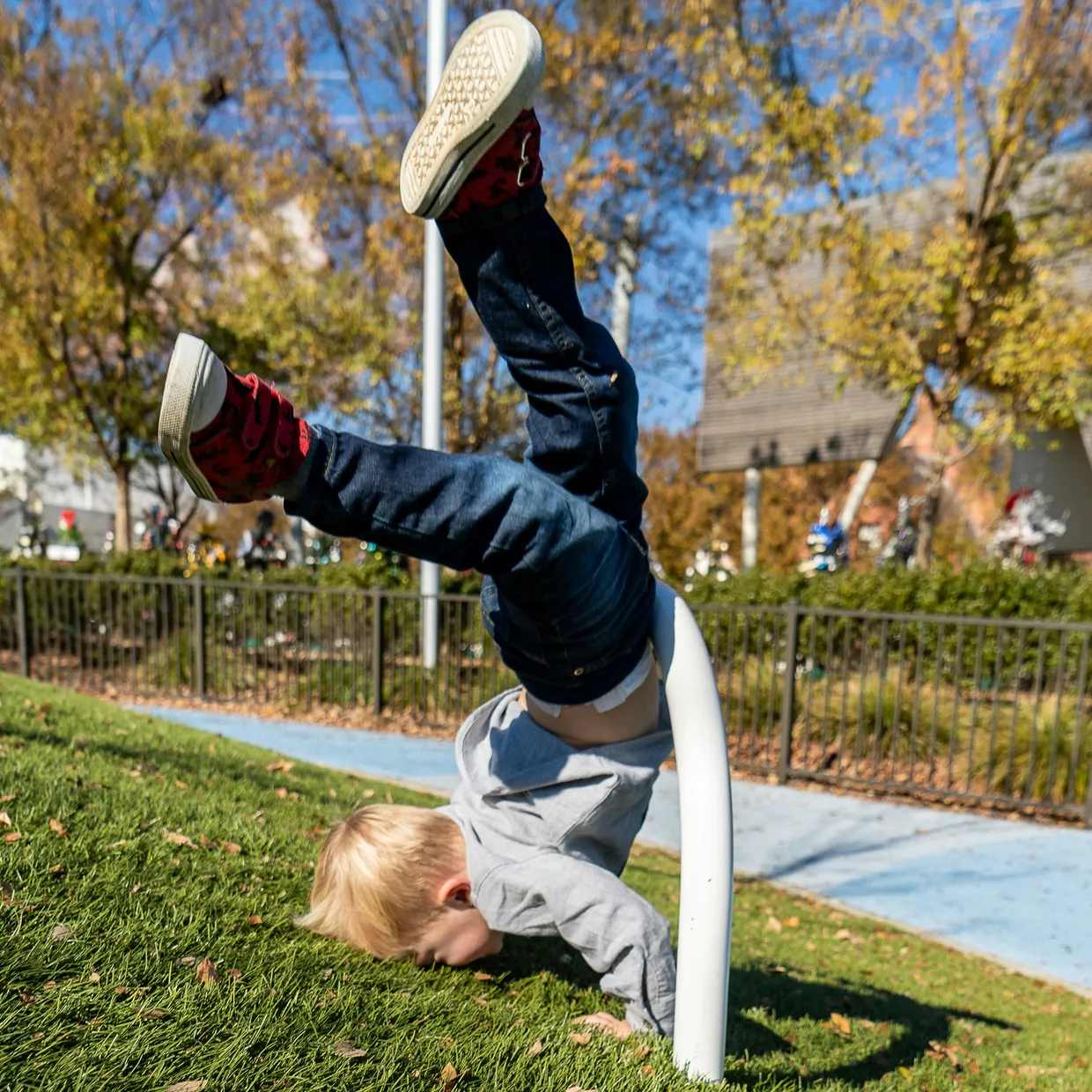 a child falling over a metal bar by Zachary Kadolph