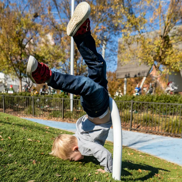 a child falling over a metal bar by Zachary Kadolph